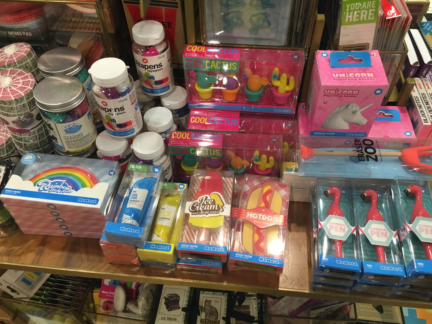 Colorful novelty stationery, including flamingo pens, rainbow sticky notes, and quirky desk accessories.