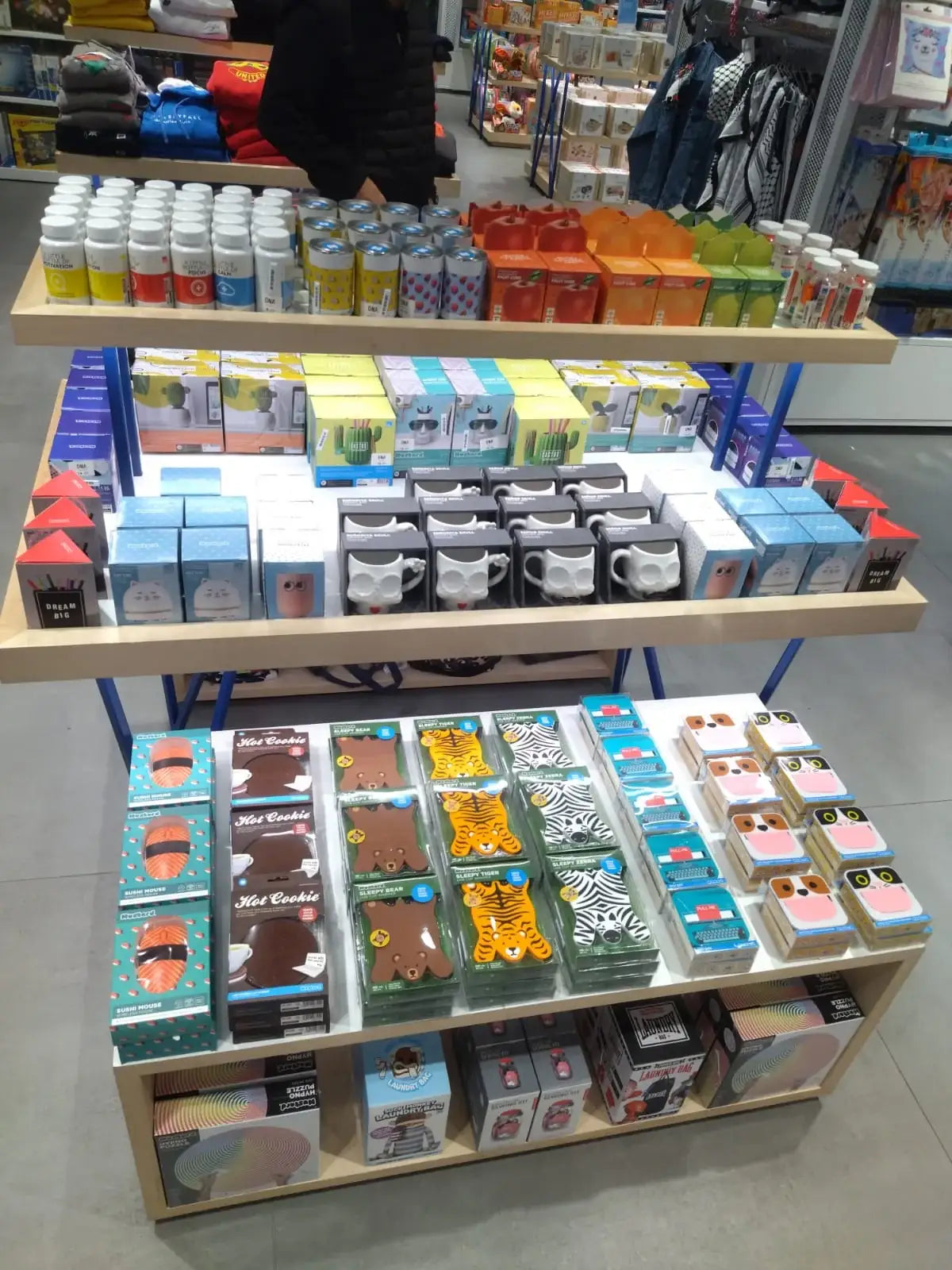 Colorful desk accessories and novelty stationery items on display shelves in a retail store.